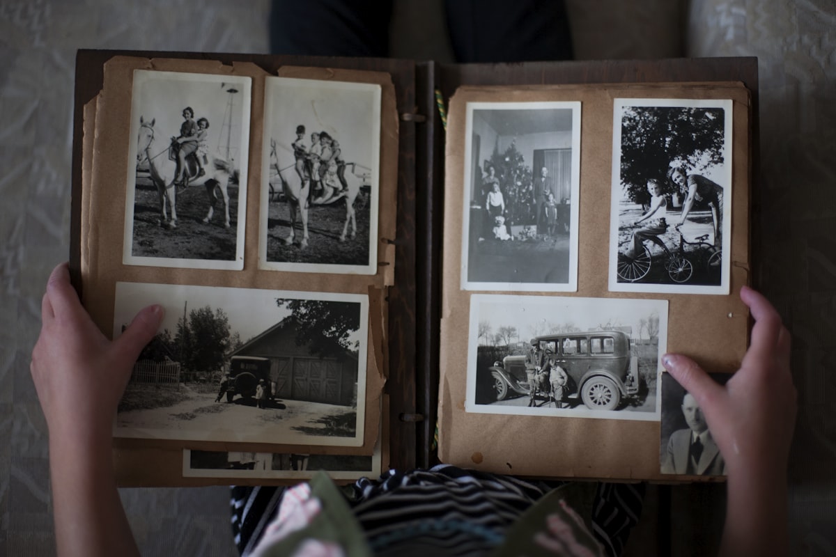 Hands holding open an old family photo album